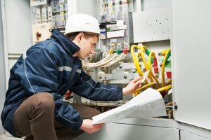 Electrician checking on the wiring system of a commercial building.