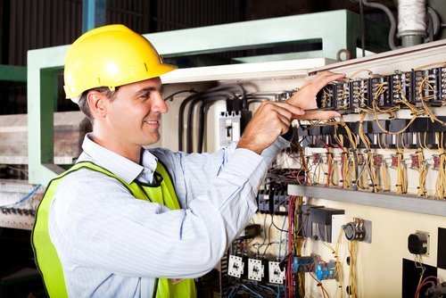 electrician repairing industrial machine Ajax Electrical employee on Industrial job