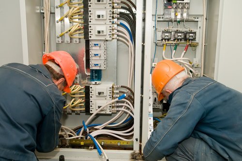 Electricians fixing industrial circuit lines